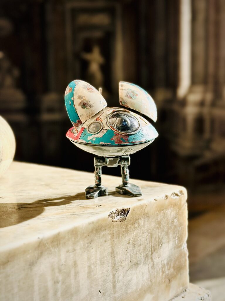 Small colorful sci-fi droid model on a stone ledge