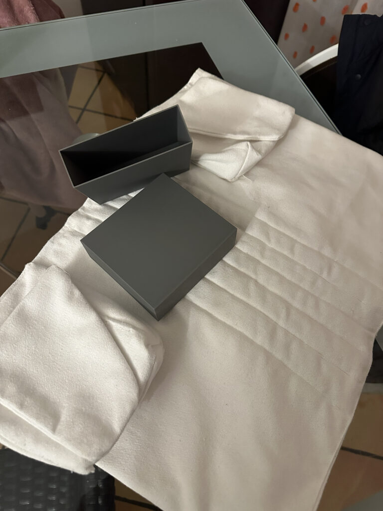 White quilted costume garment with two gray pieces laid on top