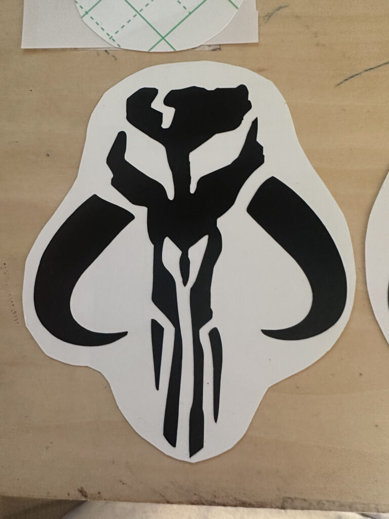 Large black skull emblem vinyl sticker on backing paper