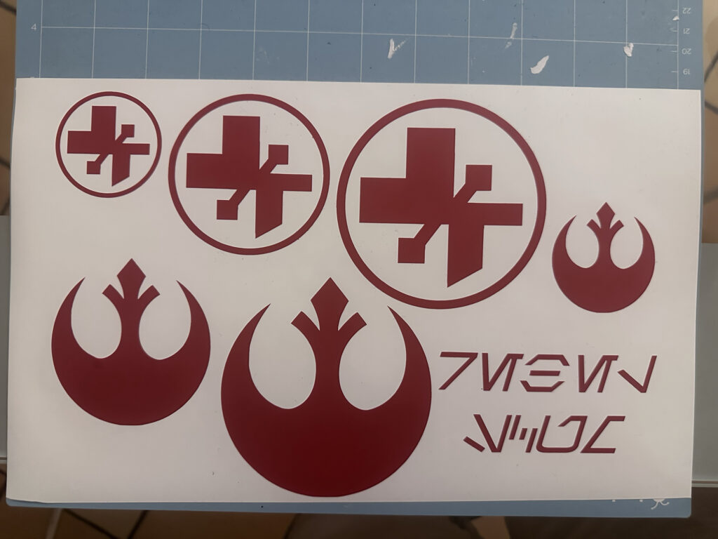 Red emblem and lettering decals on a transfer sheet