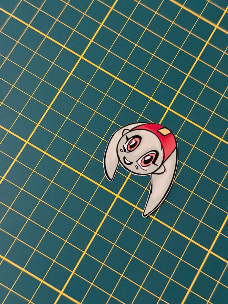 Small illustrated character sticker on a cutting mat