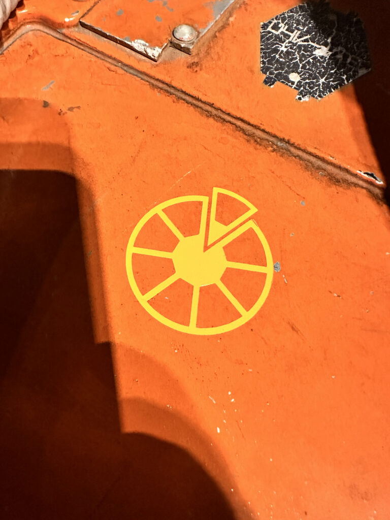 Yellow circular vinyl decal on an orange prop