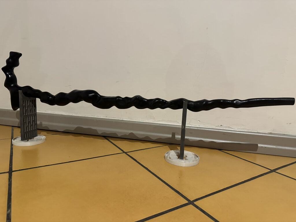 Long black twisted staff prop supported upright