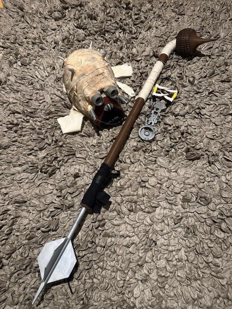 Weathered staff prop and costume accessories on the floor