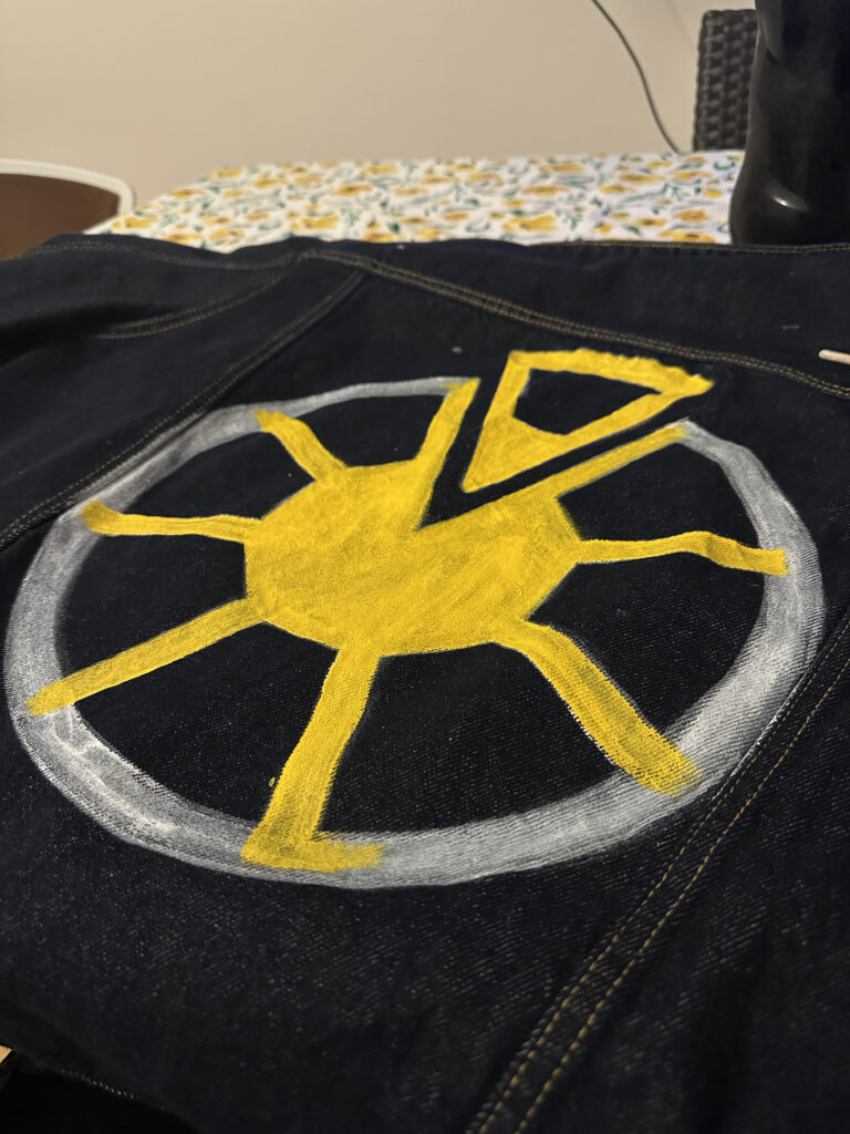 Close-up of a yellow emblem sewn onto a dark jacket