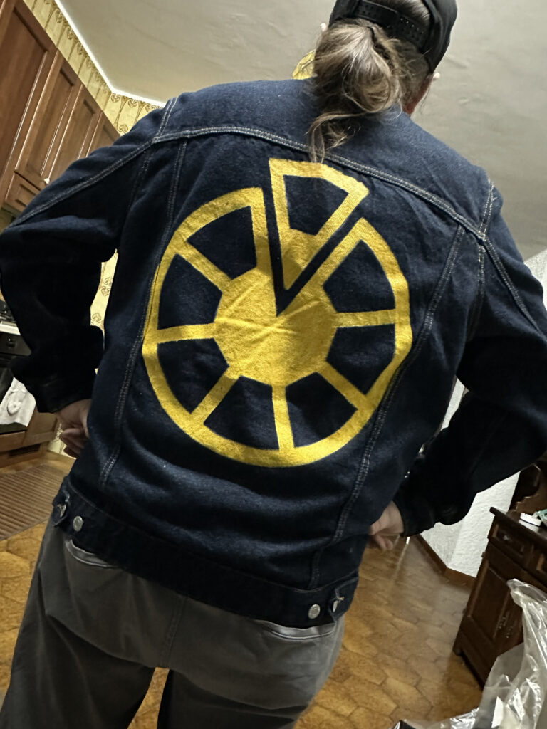 Dark jacket with a large yellow custom emblem